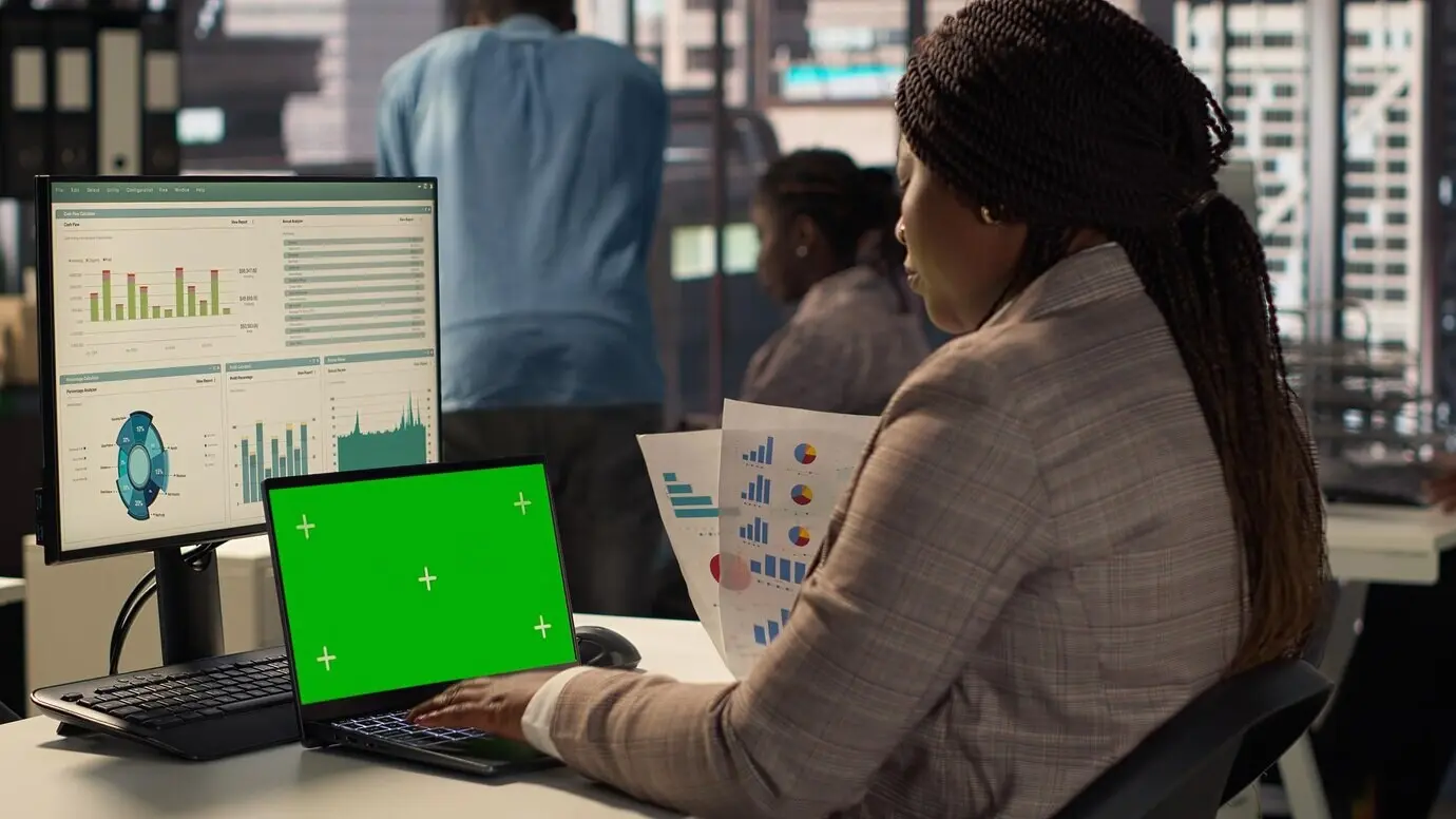 Корпоративный сотрудник, сосредоточенный на стратегическом планировании, рядом с зелёным экраном.